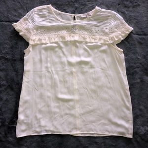 Cream colored blouse with floral lace detailing.